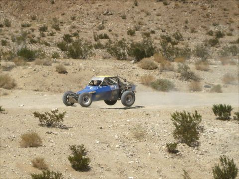 1996 Ford Bronco - Off-road buggy races through a dusty desert environment.