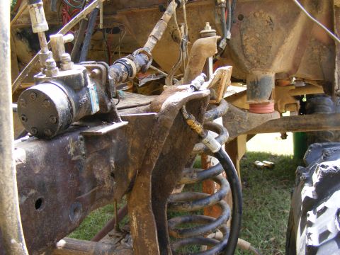 1978 Ford Bronco - Undercarriage view of a heavily modified off-road vehicle, focusing on suspension and steering parts.