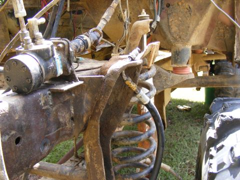1978 Ford Bronco - Close-up view of the heavily rusted suspension and chassis of an off-road vehicle.