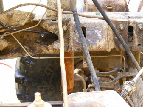 1978 Ford Bronco - Detail shot of heavily corroded vehicle chassis components and a tire.