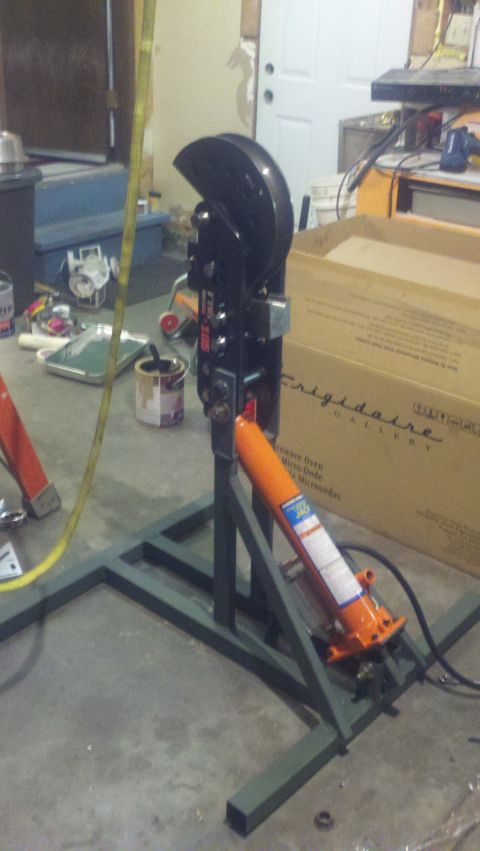 1988 Ford Bronco - A hydraulic metal bender is set up on a stand, with an orange hydraulic jack attached.