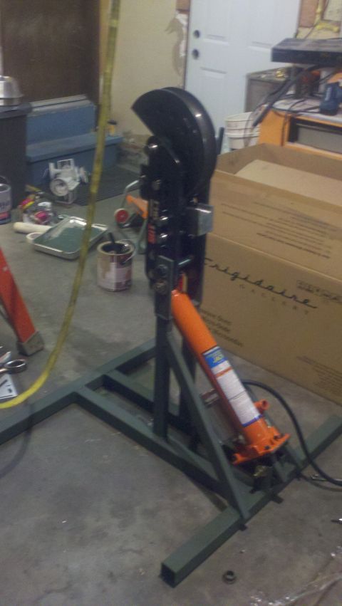 1988 Ford Bronco - A hydraulic jack assembly is shown in a workshop setting with various tools and boxes in the background.
