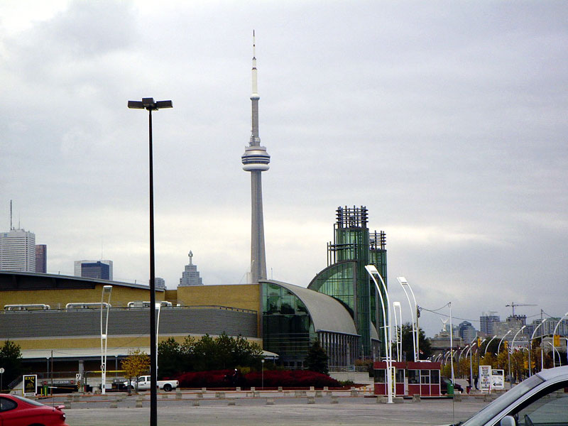 Toronto skyline the CN Tower and a modern convention center under a cloudy sky