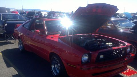 1978 Ford Mustang II - A red 1975 Ford Mustang II coupe is displayed with its hood open at an outdoor event.