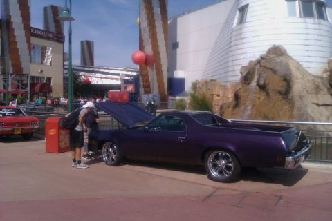 1991 Ford LTD Crown Victoria - A purple El Camino is parked with its hood up, showing off its custom wheels.