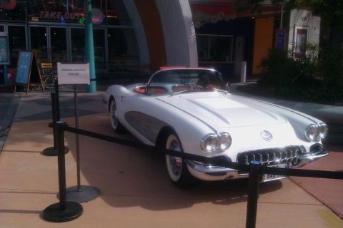 1991 Ford LTD Crown Victoria - A vintage white convertible is displayed in front of a building with a 'TAKE OUT' sign.