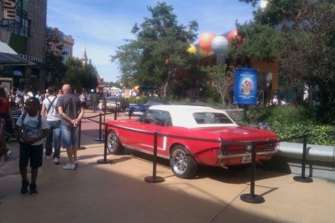 1991 Ford LTD Crown Victoria - A red convertible classic car is on display in a public area with people walking by.