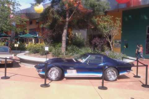 1991 Ford LTD Crown Victoria - A blue 1969 Chevrolet Corvette Stingray is displayed next to another vehicle in an outdoor plaza.
