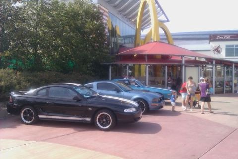 1991 Ford LTD Crown Victoria - Three Ford Mustangs are parked in a row outside a McDonald's restaurant.