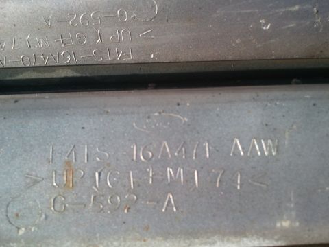 1996 Ford Bronco - A close-up view of a metal plate showing stamped Ford branding and part identification numbers.