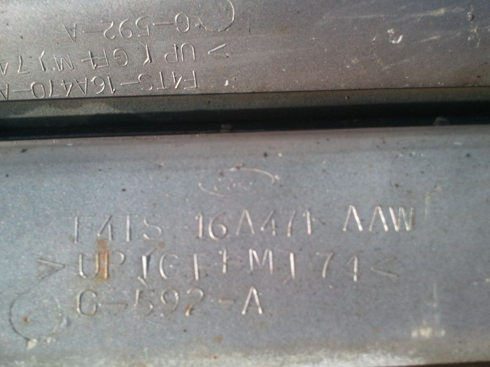 Metal plate with stamped Ford logo and part numbers