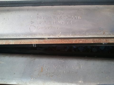 1996 Ford Bronco - Close-up of stamped metal parts showing Ford branding and part numbers.