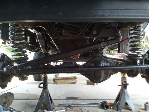 1996 Ford Bronco - The underside of a vehicle is shown, lifted on jack stands for maintenance or repair.