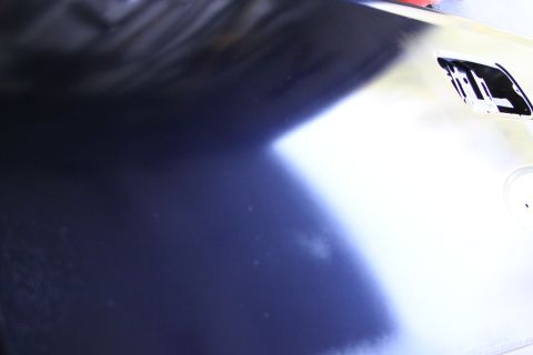2006 Ford F-350 - A close-up view of a dark blue fender, likely from a 2006 Ford F-350, shows a bright white reflection and a Supermotors.net watermark.