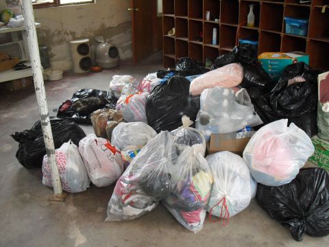 1986 Ford Bronco - A collection of trash bags and boxes are gathered on a floor, with shelving units in the background.