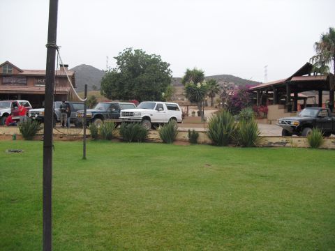 1986 Ford Bronco - A group of trucks and SUVs are parked in front of a building with a covered outdoor seating area.