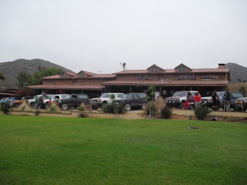 1986 Ford Bronco - Group of SUVs parked outside a building, likely a gathering spot for off-road enthusiasts.