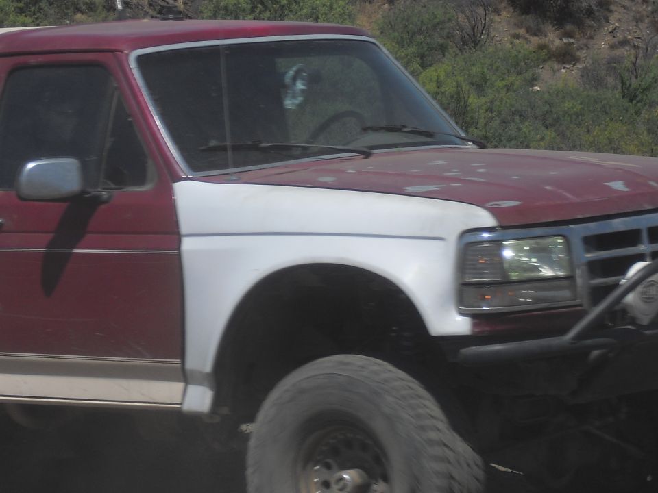 Red and white Ford Bronco, 3/4 front view. Appears to be a 1987-1991 model
