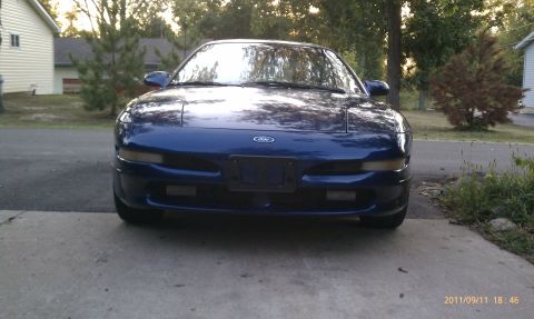 1994 Ford Probe - 1994 Ford Probe front view, parked on a concrete driveway with houses and trees in the background.