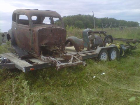 1978 Chevrolet C/K Pickup - Rusted car body and chassis being transported on a trailer.