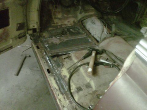 1978 Chevrolet C/K Pickup - The floor of a vehicle is being repaired, showing exposed metal and welding supplies.