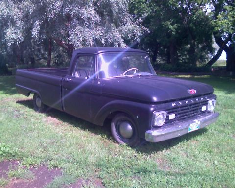1978 Chevrolet C/K Pickup - A dark blue 1960 Mercury pickup truck is parked on a grassy lawn with trees in the background.
