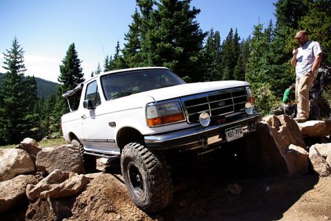 1995 Ford Bronco - A white Ford Bronco navigates a challenging rocky trail in Colorado.