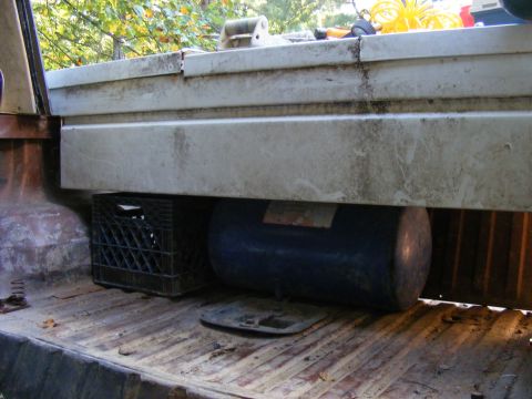 1978 Ford Bronco - Interior of a truck bed with a toolbox, milk crate, and air tank visible.