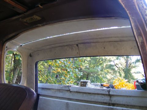 1978 Ford Bronco - The interior of a 1978 Ford Bronco shows the rear window looking out onto a wooded area.