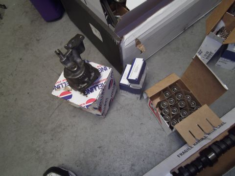 1991 Chevrolet Blazer - Various engine components, including a pump and valve springs, are laid out on the floor next to their packaging.