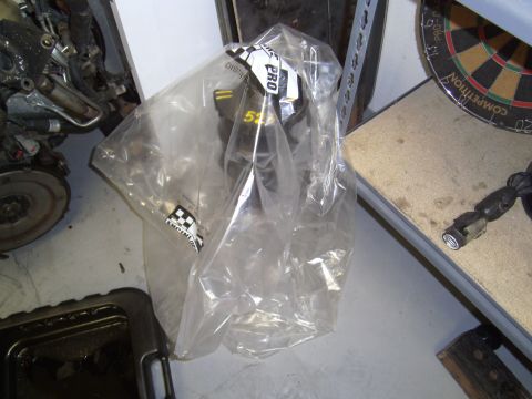 1991 Chevrolet Blazer - An engine part is packaged in plastic, with a disassembled engine nearby.
