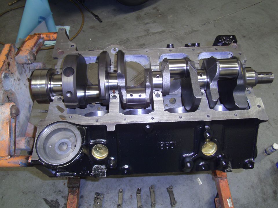 Engine block with crankshaft installed, mounted on an orange engine stand