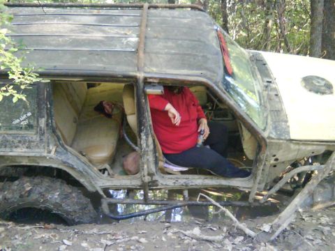 1978 Ford Bronco - This heavily modified off-road vehicle appears to be stuck deep in mud, with a person visible inside.