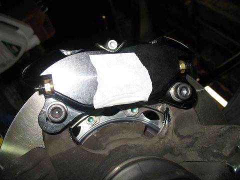 1993 Mazda MX-3 - Close-up view of a vehicle's brake caliper and rotor assembly, showing a new brake pad.