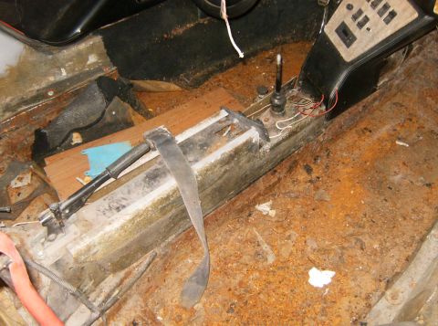 2000 Ford E350 - The interior floor and center console show significant rust and debris, indicating a state of disrepair.
