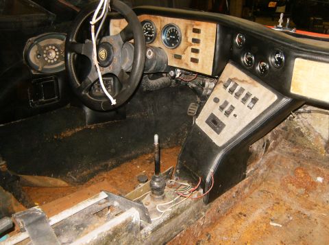 2000 Ford E350 - Interior view of a car's dashboard, steering wheel, and center console, showing signs of wear and rust.