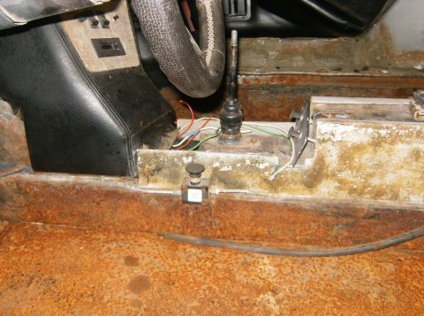 2000 Ford E350 - The interior floor console, shifter, and heavily rusted floor pan are visible in this image.