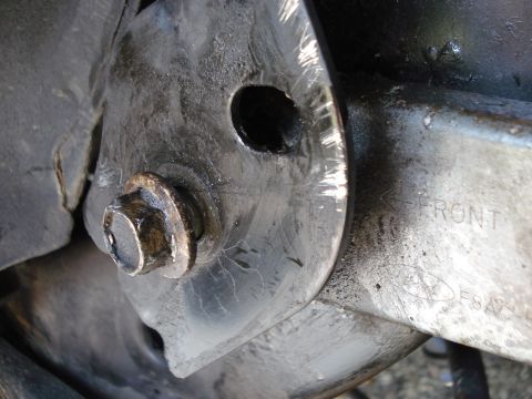 2000 Ford Crown Victoria - A close-up view of a vehicle's suspension component, showing a bolt and the word 'FRONT' stamped into the metal.
