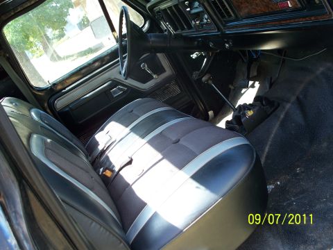 1979 Ford F-250 - The interior of a 1979 Ford F-250 features a two-tone bench seat and wood-grain trim on the dashboard.