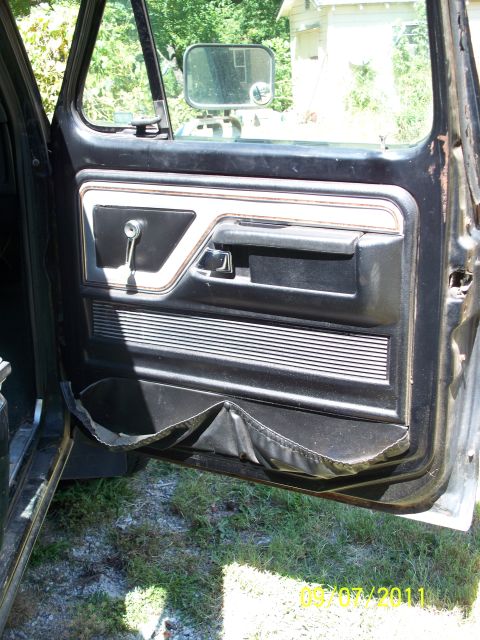 1979 Ford F-250 - The interior door panel of a 1979 Ford F-250 shows wear and tear, including a ripped map pocket.