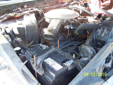 1979 Ford F-250 - Engine bay view of a 1979 Ford F-250, showing the battery, air cleaner, and various engine components.