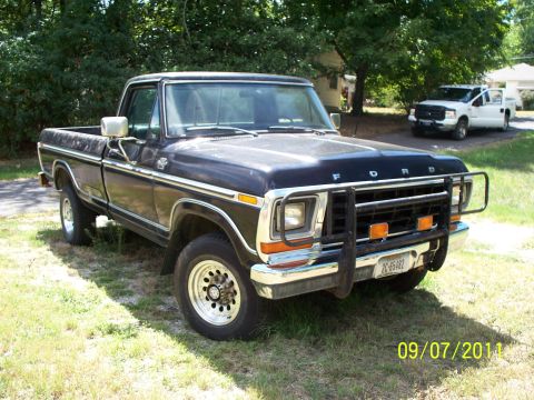 1979 Ford F-250 - Front three-quarter view of a dark blue late-1970s Ford F-Series pickup with a chrome front bumper, a black grille guard with two amber lig…