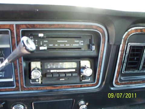 1979 Ford F-250 - The interior of a 1979 Ford F-250 shows the dashboard with climate controls and radio, wood grain trim.