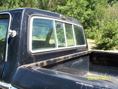 1979 Ford F-250 - This black 1973 Ford F-100 pickup truck shows rust on its bed rails and a sliding rear window.