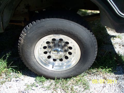 1979 Ford F-250 - Close-up of a chrome alloy wheel and Firestone A/T tire on a vehicle.