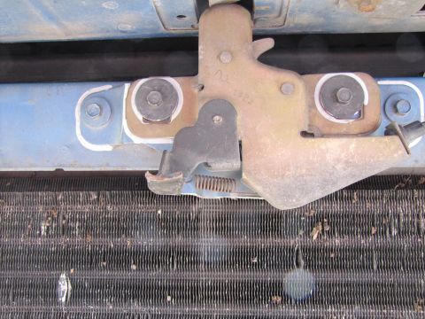 1993 Ford F-250 - Close-up view of a vehicle's hood latch mechanism situated above a radiator.