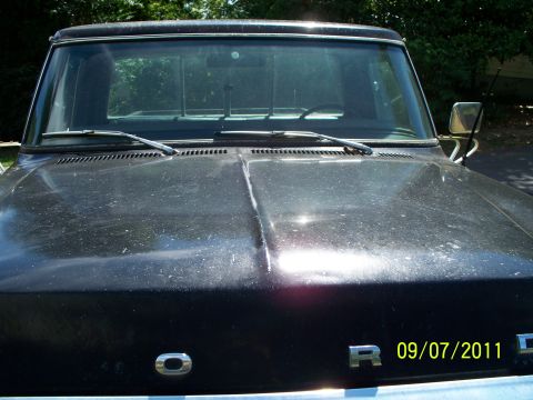 1979 Ford F-250 - The photo shows the front of a dark-colored pickup truck, focusing on the hood and windshield area.