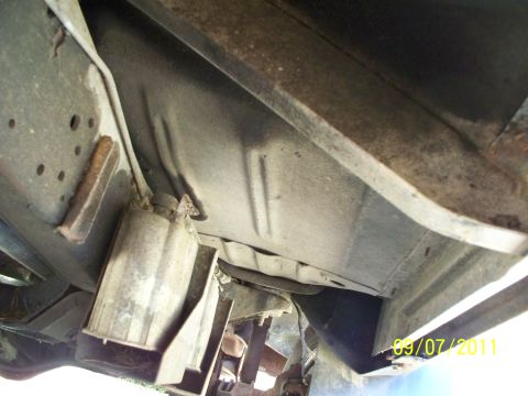 1979 Ford F-250 - The underside of a vehicle is visible, with focus on the frame and fuel tank assembly.