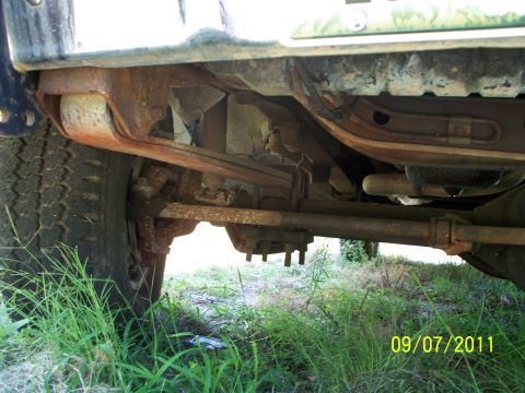 1979 Ford F-250 - Underside view of a truck's suspension system, including leaf springs and a tire.