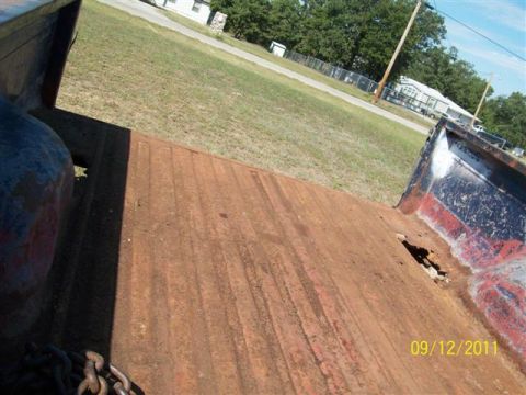 1979 Ford F-150 - The rear of a 1979 Ford F-150 shows a worn truck bed with visible rust and chain.